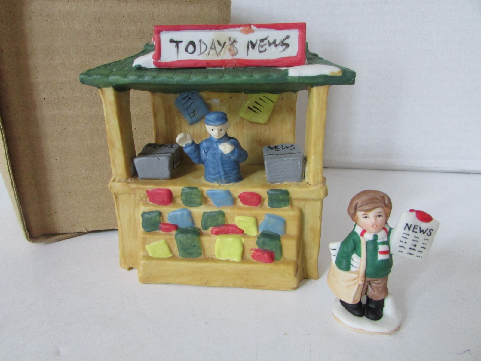 VTG PORCELAIN NEWSTAND 4-1/2″H WITH PAPERBOY 2.25″H HOLIDAY VILLAGE LAYOUT ACCES