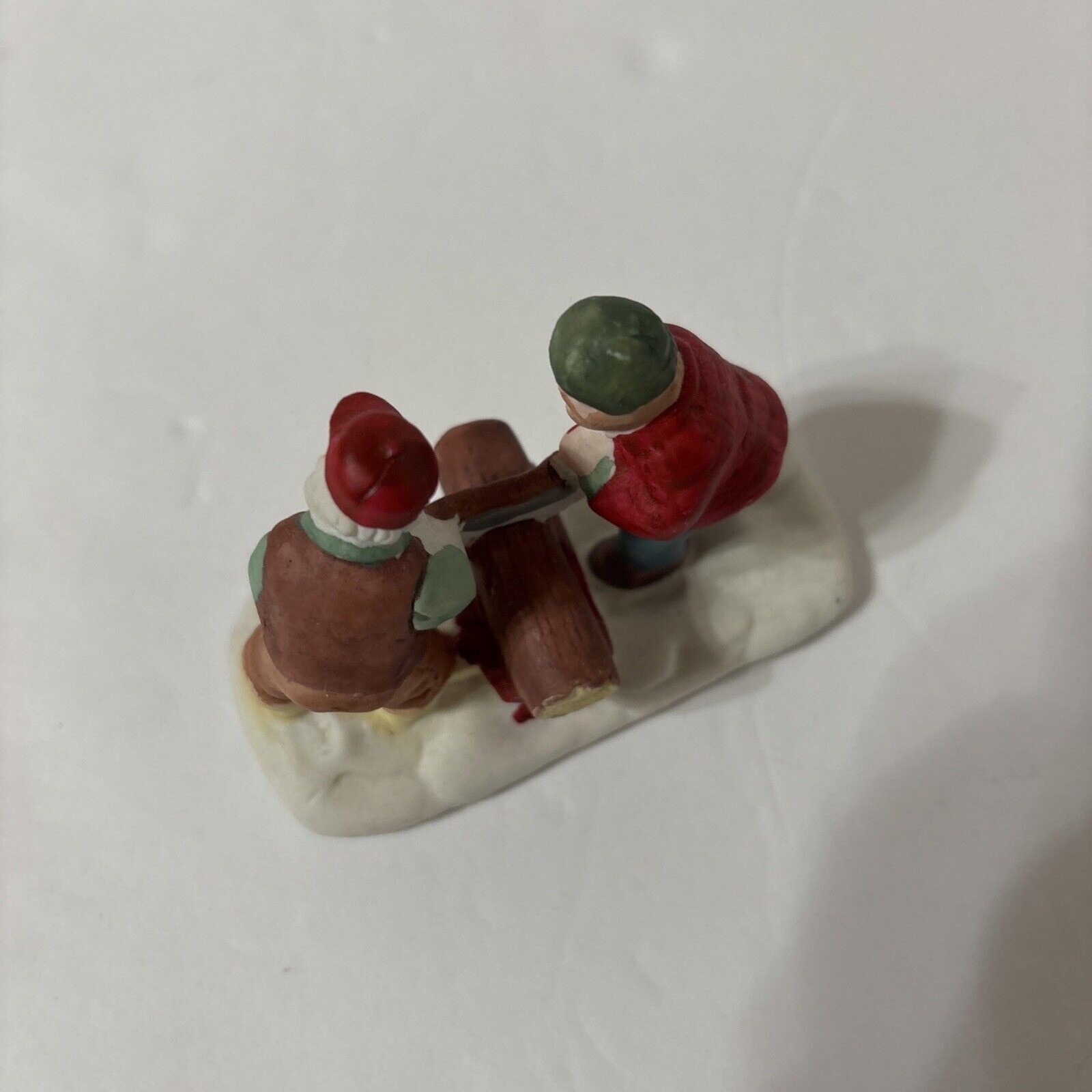 Porcelain Christmas Village Figurine. Sawing Wood
